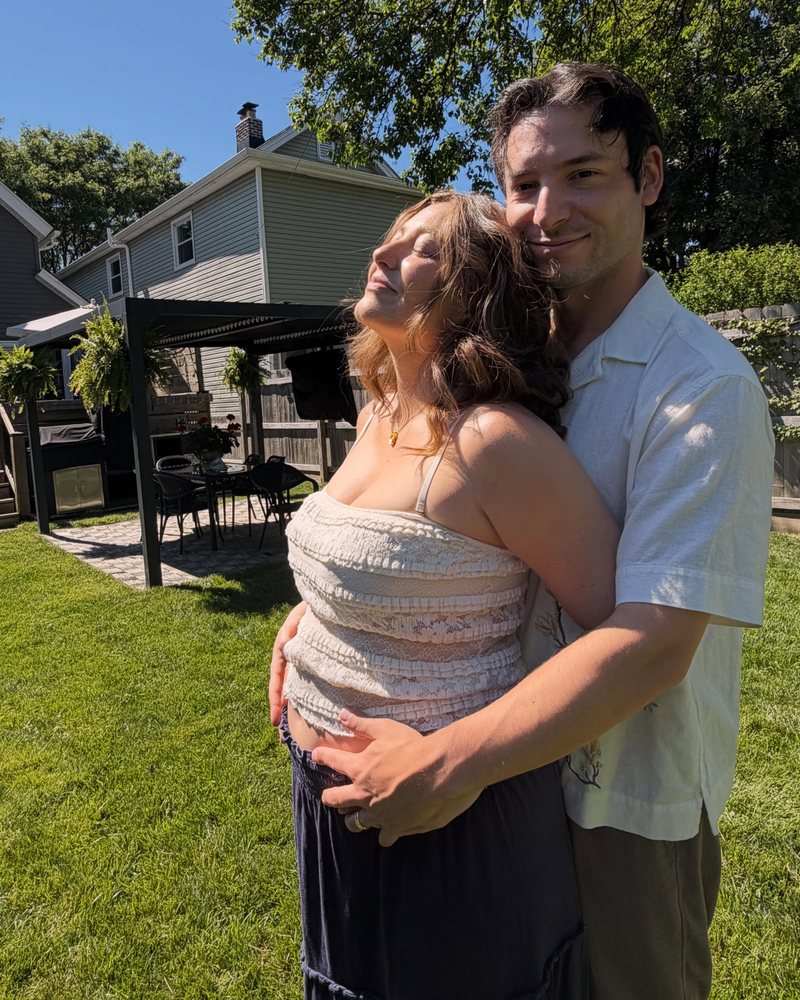 Joseph and Mandy in the backyard, arms around the baby bump